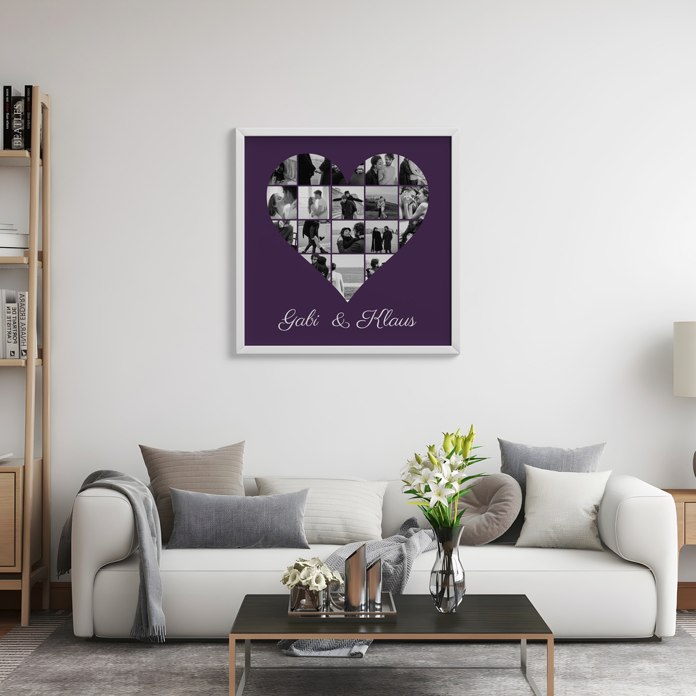 Collage di foto in bianco e nero a forma di cuore, con nomi e cornice bianca sopra il divano in soggiorno