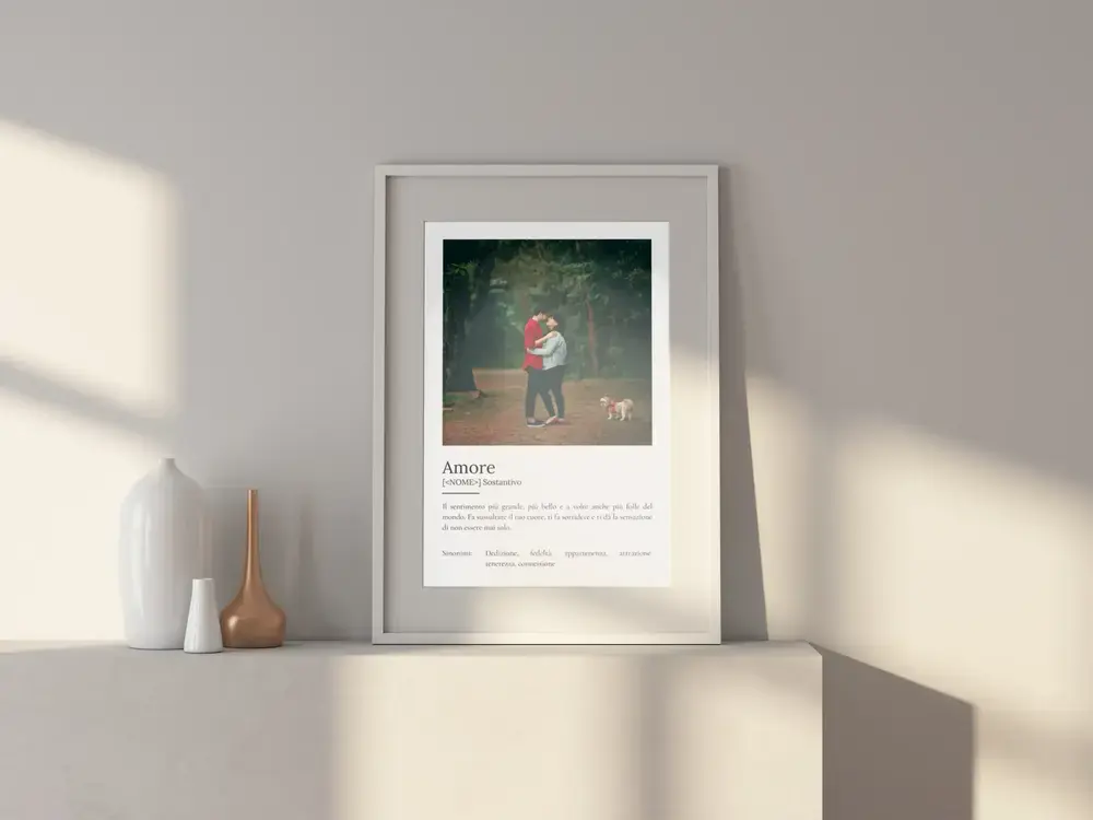 Poster dell’amore con foto di coppia, in cornice bianca su una madia: un pensiero personalizzato per gli sposi