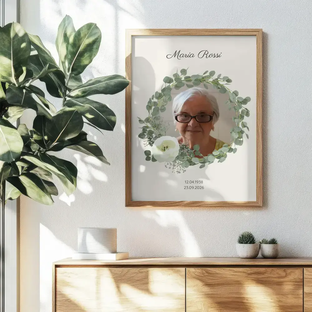Quadro commemorativo con ritratto e ghirlanda di eucalipto, in cornice di legno sulla parete sopra una credenza