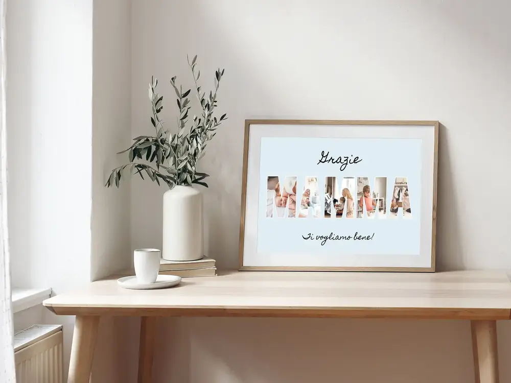 Collage fotografico per la mamma con foto nelle lettere e fondo azzurro, in cornice di legno su una scrivania